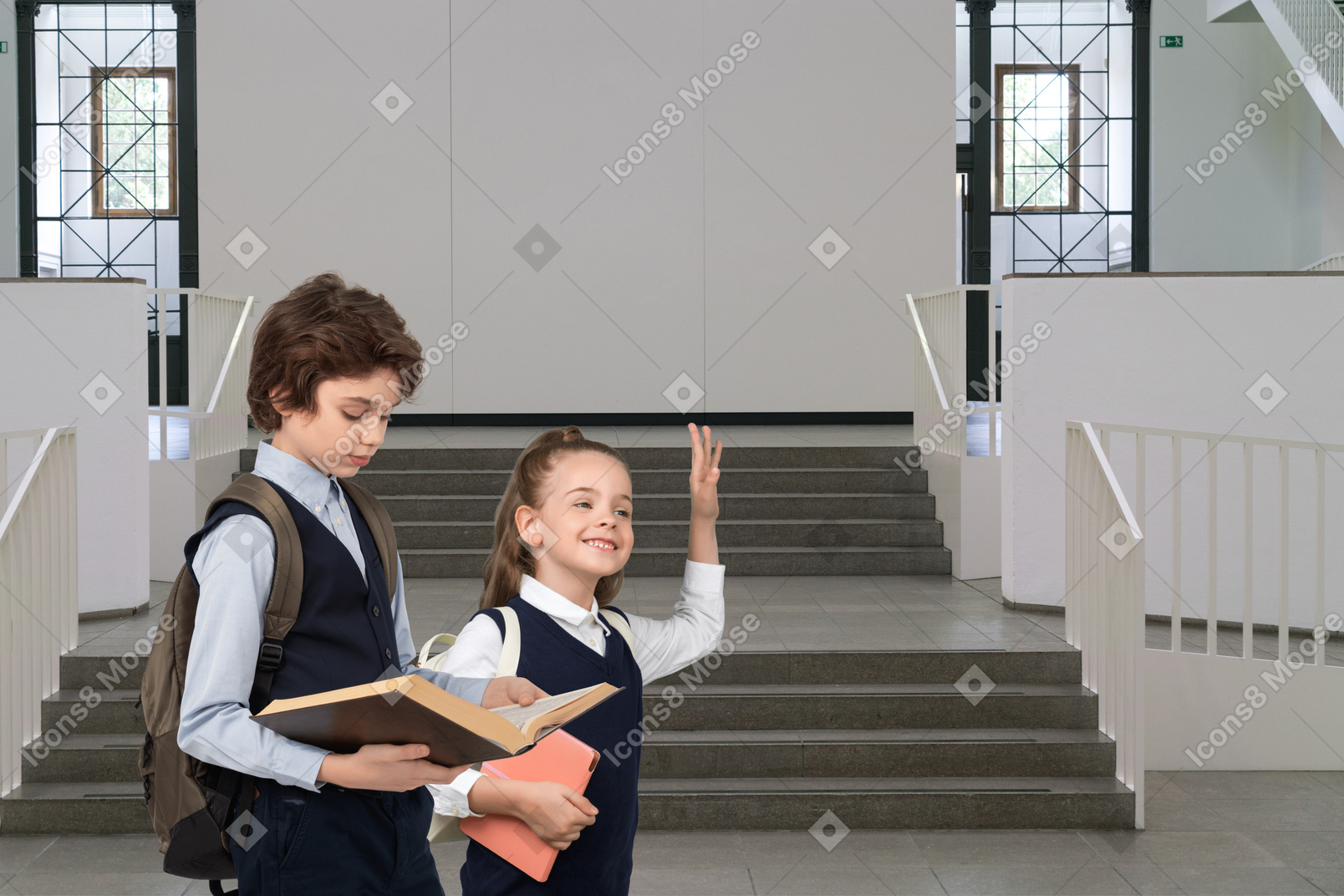 Schoolboy and schoolgirl standing in front of stairs