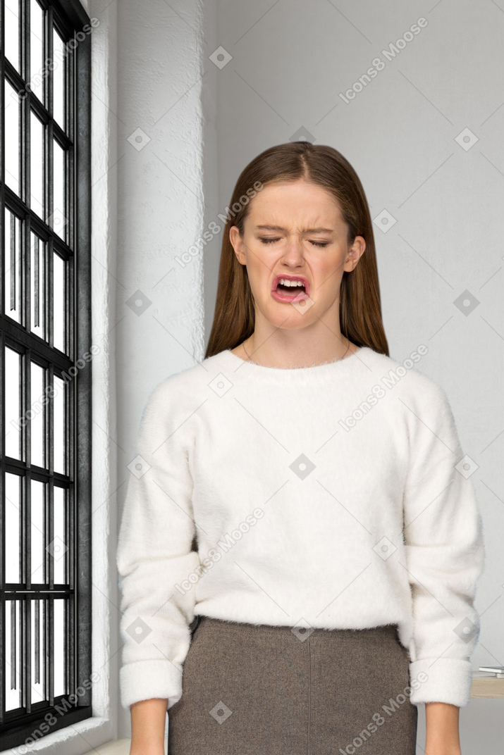 Distressed woman standing next to a window