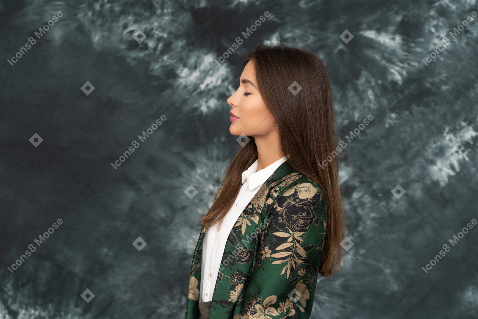 Side shot of young businesswoman standing with her eyes closed