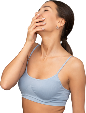 Close-up rindo mulher com sutiã esportivo escondendo a boca