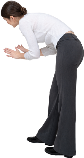 Vista lateral de uma jovem com roupas casuais, curvando-se