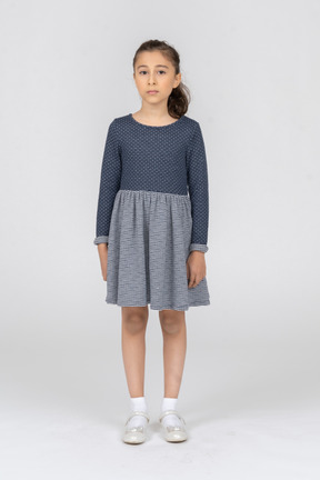 Full length of a girl in a gray dress standing