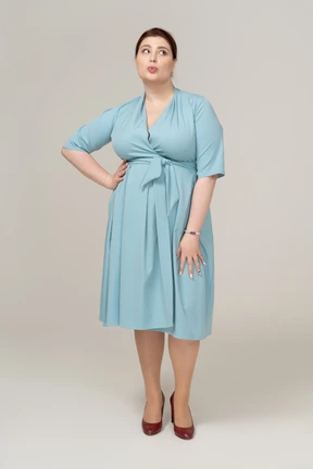 Front view of a woman in blue dress blowing a kiss