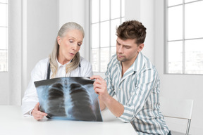 A man and woman looking at an x - ray