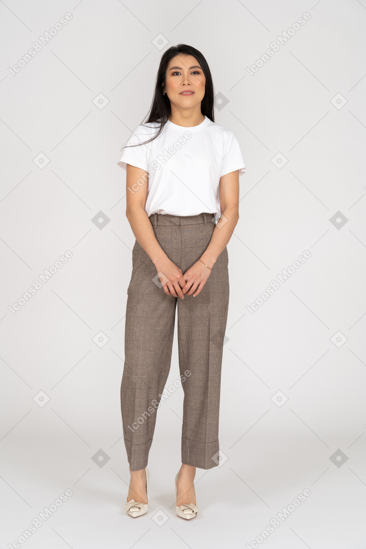 Front view of a young lady in breeches and t-shirt holding hands together