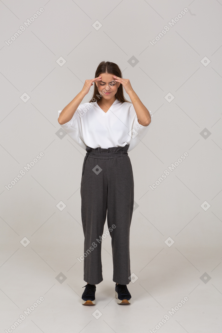 Front view of a young lady in office clothing touching head