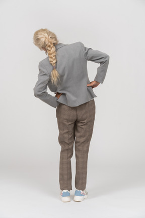 エクササイズをしているスーツの老婦人の背面図