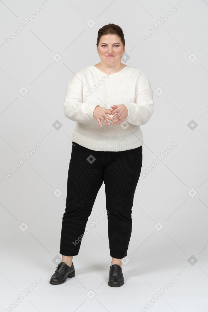 Happy plump woman in white sweater making faces