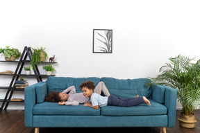 Cute boy and girl laying on sofa