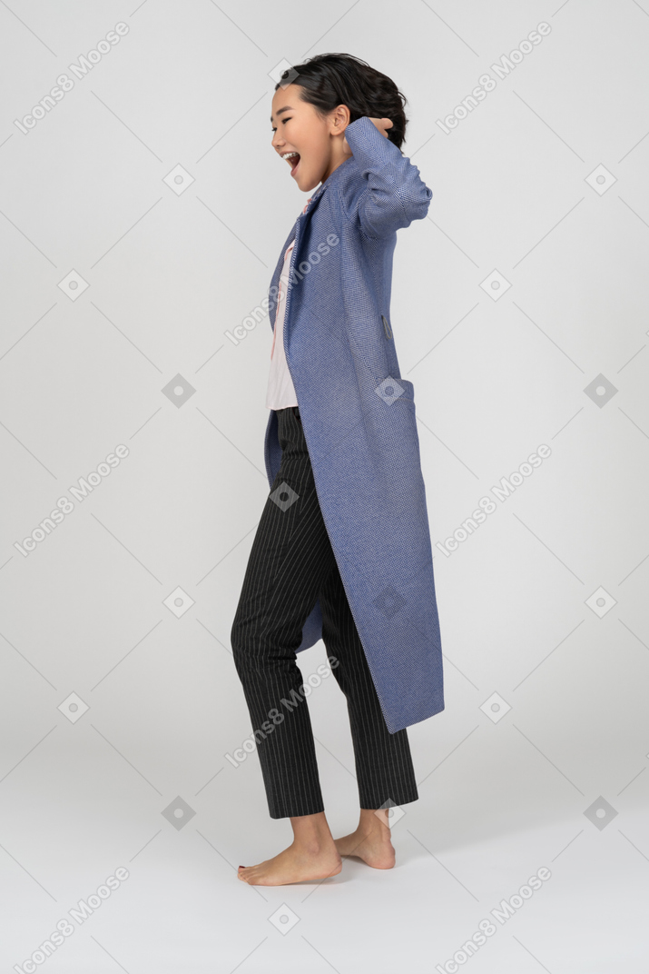 Vista lateral de uma mulher excitada de casaco