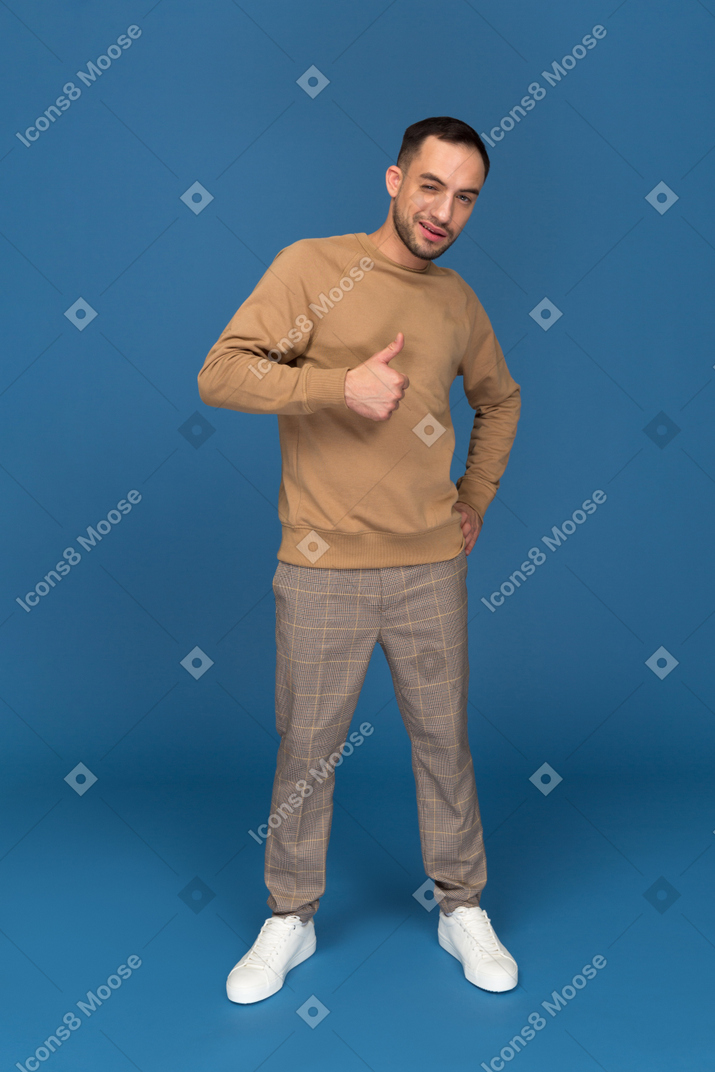 Young man showing thumb up and winking