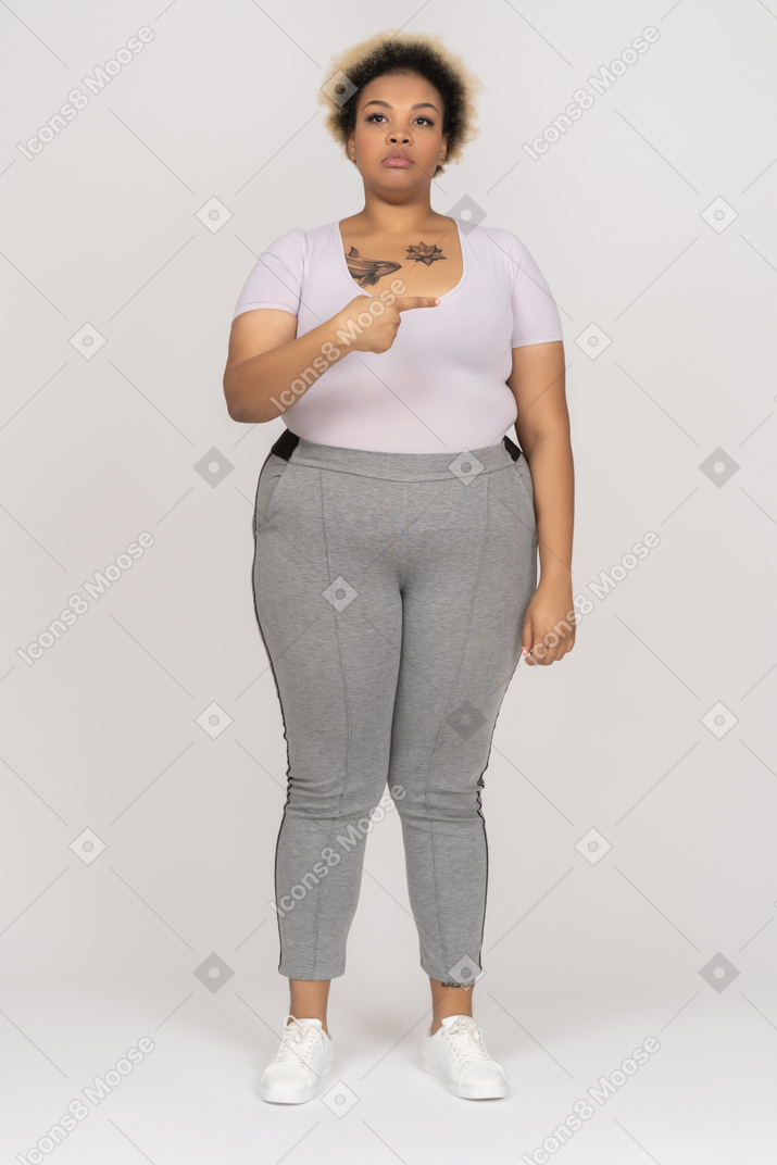 Plus size model pointing sideways with a finger