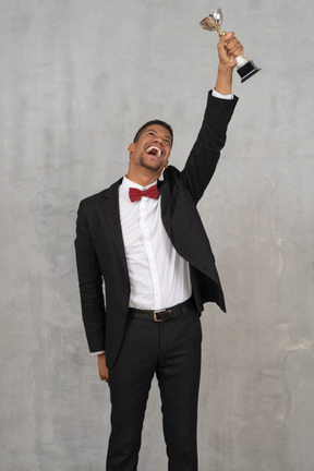 Man holding up award in celebration of his win