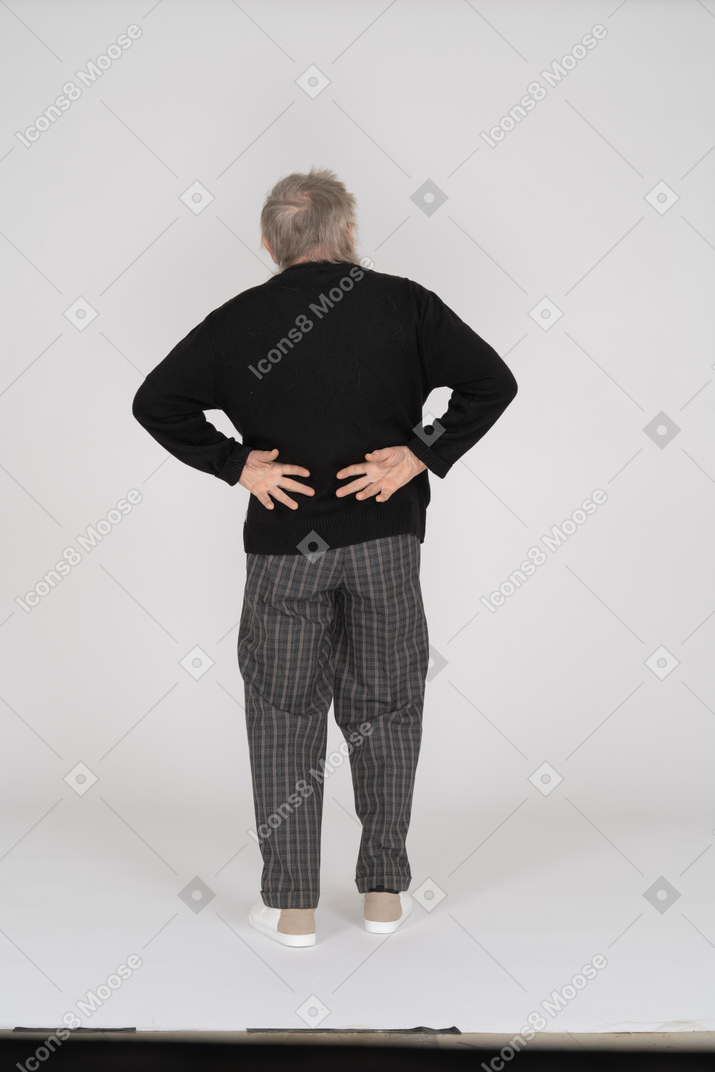 Back view of old man with hands behind back