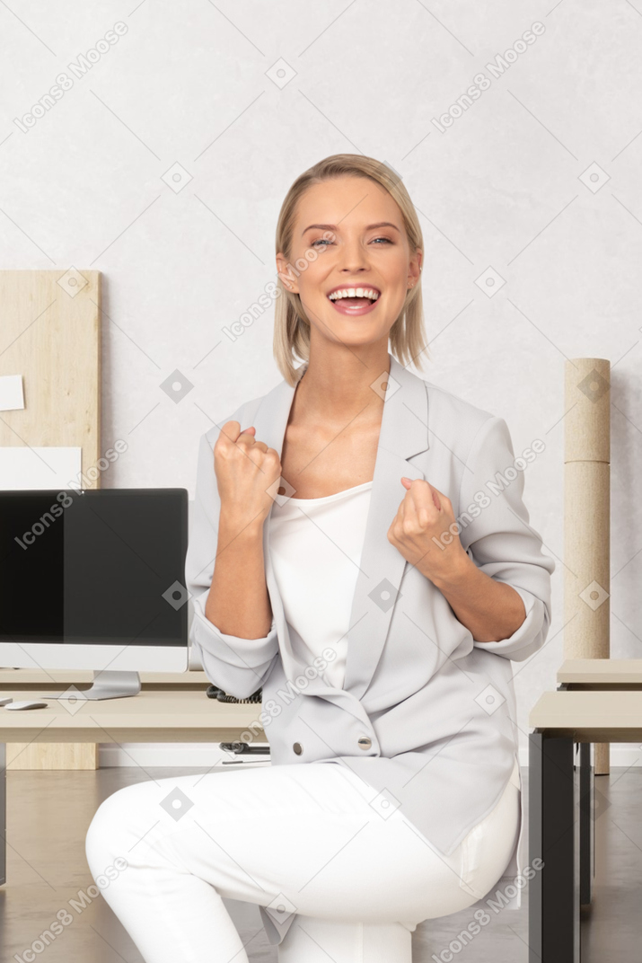 A woman sitting on a chair in front of a desk