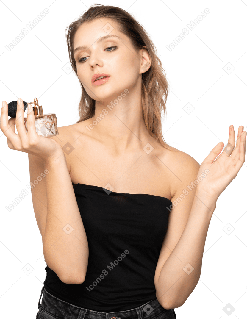 Vista frontal de uma jovem sensual segurando um frasco de perfume
