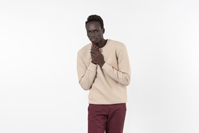 A young black man in a grey sweater standing alone on the white background