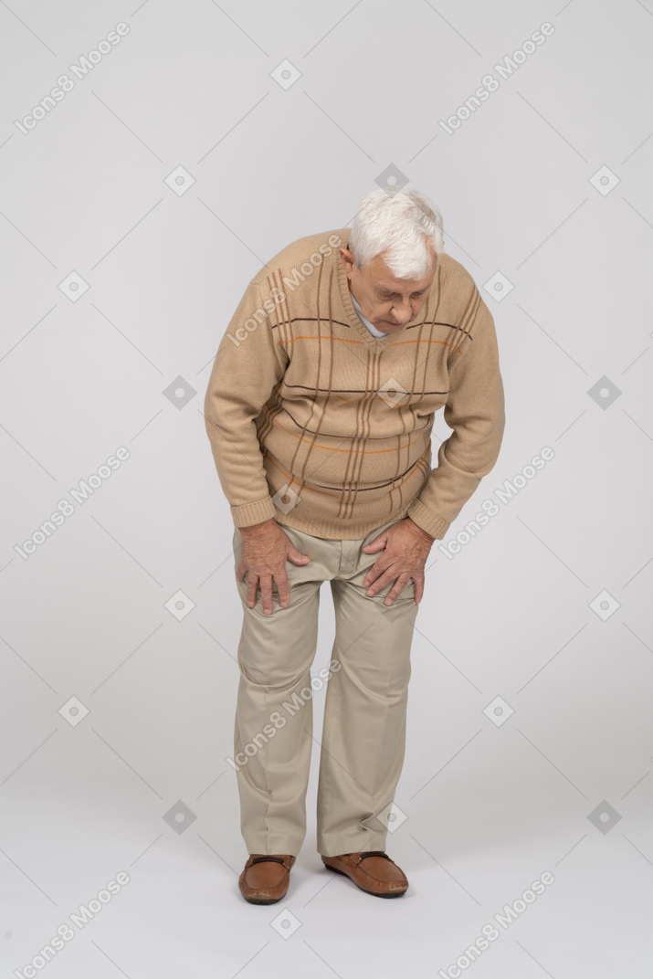 Vista frontal de um velho em roupas casuais, olhando para baixo