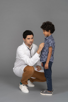 Médico examinando criança pequena