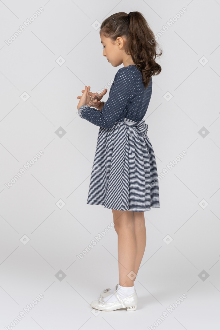 Side view of a girl fiddling with her fingers