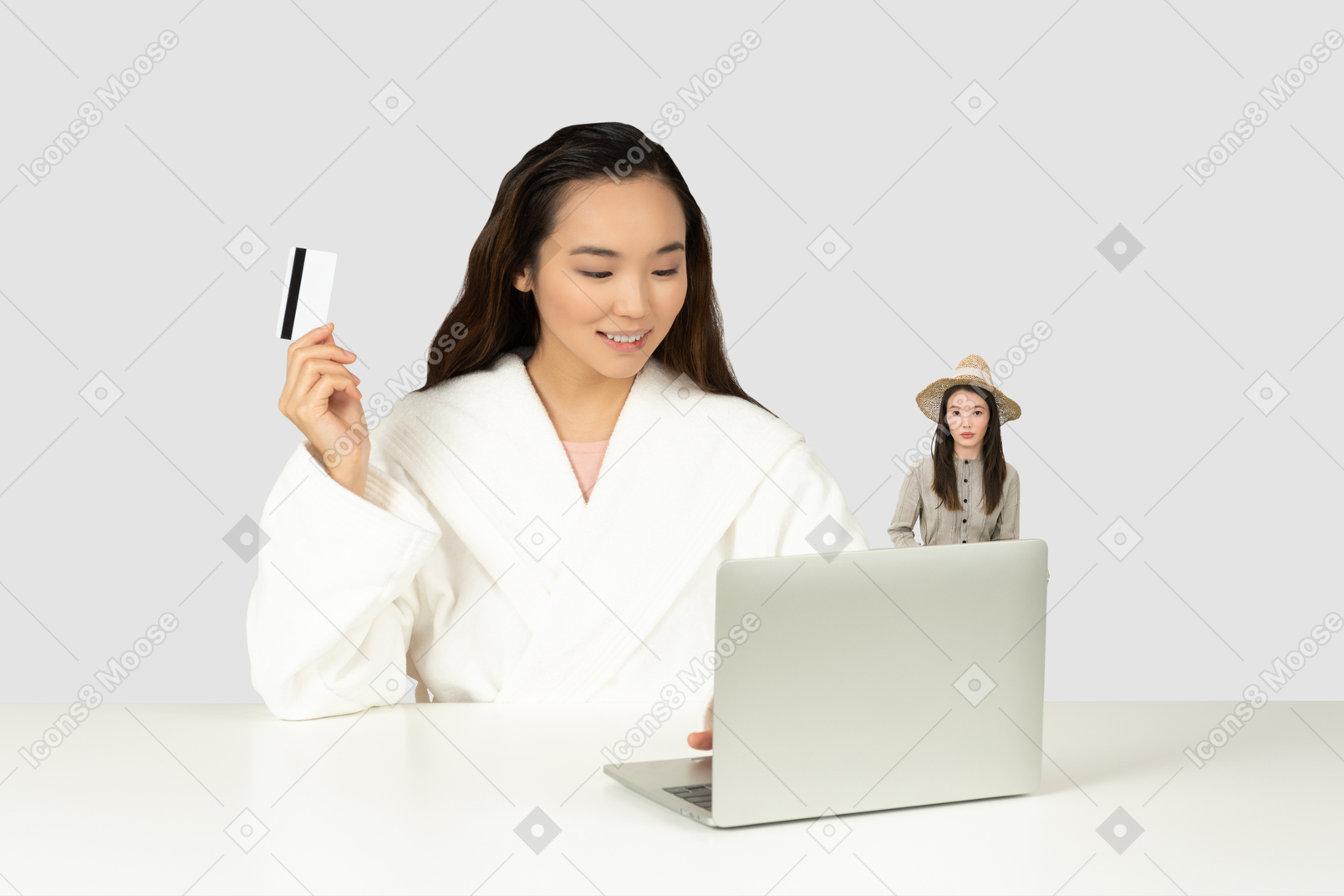 Woman in front of laptop holding credit card and her little copy