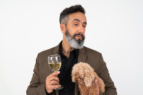 Homem maduro, segurando o cão e copo de vinho