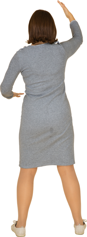 Rear view of a woman in grey dress gesturing
