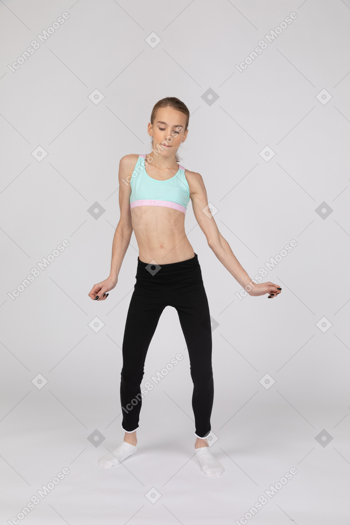 Front view of a teen girl in sportswear dancing with her eyes closed