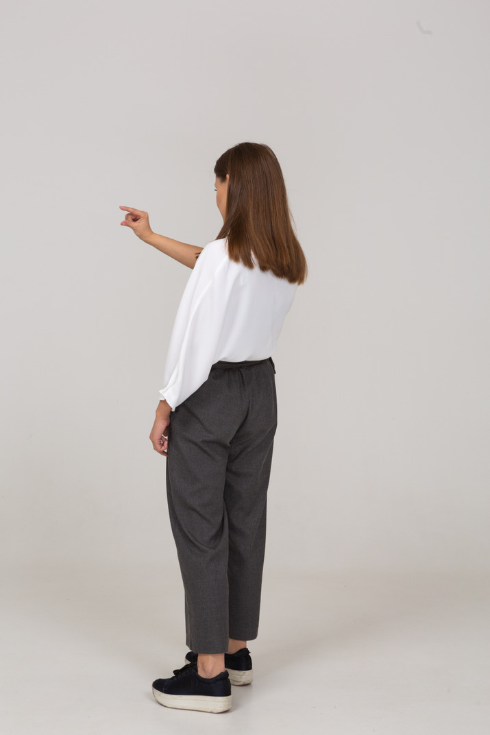 Three-quarter back view of a young lady in office clothing showing a size of something