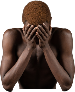 Front view of a withdrawn young afro man sitting near meat