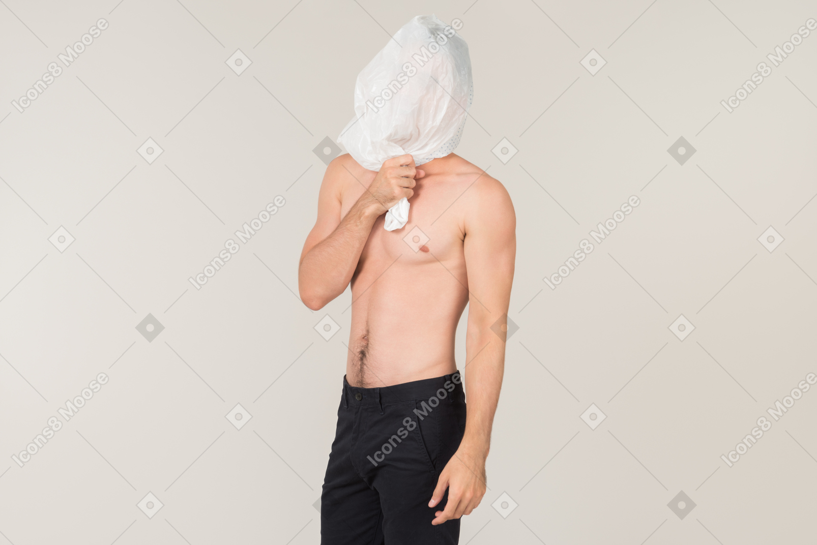 A fit young man with naked torso, putting a white plastic bag on his head
