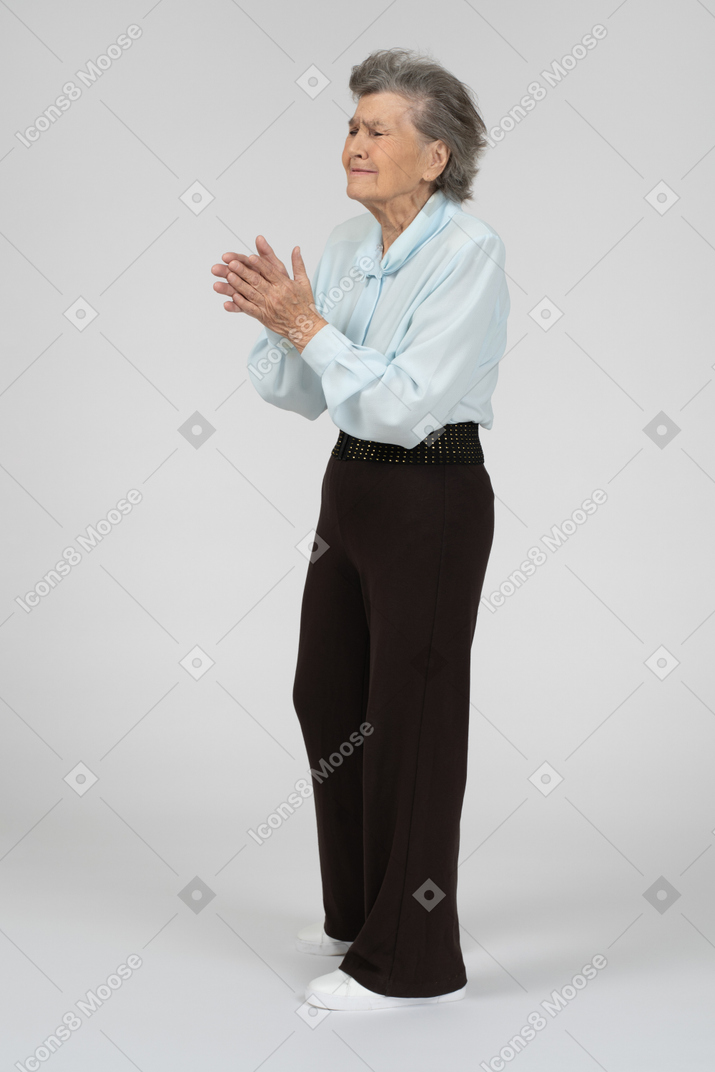 Old woman pleading with clasped hands