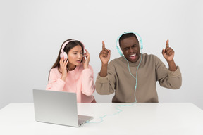 Atractiva pareja escuchando música en auriculares.