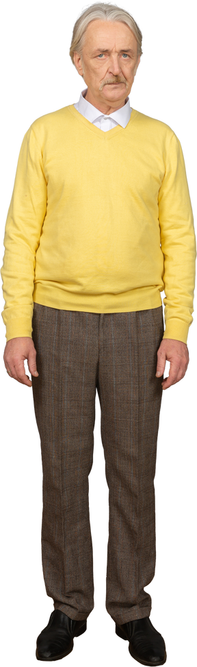 Вид спереди недовольного старика в желтом пуловере и смотрящего в камеру