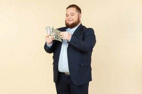 A plus-size man in a black costume with dollar bills in his hands