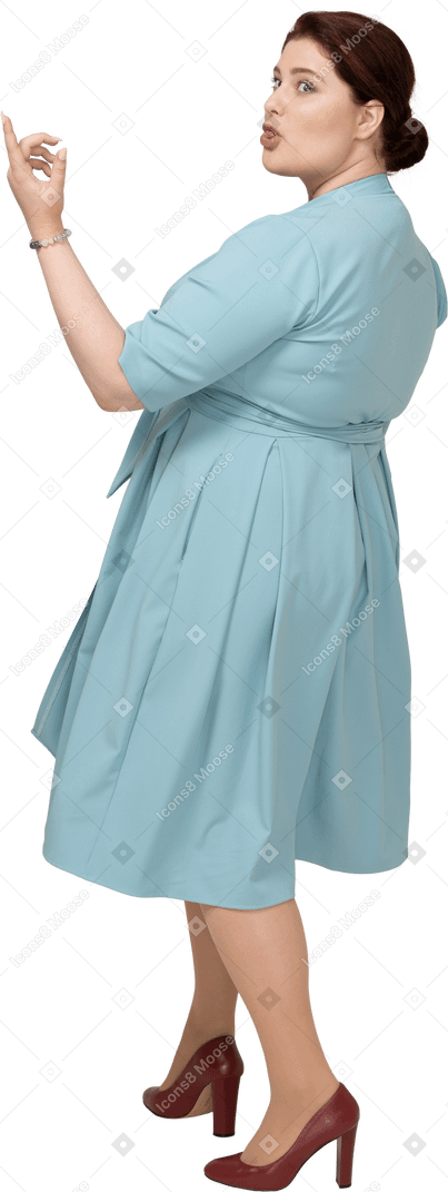 Rear view of a woman in blue dress making faces