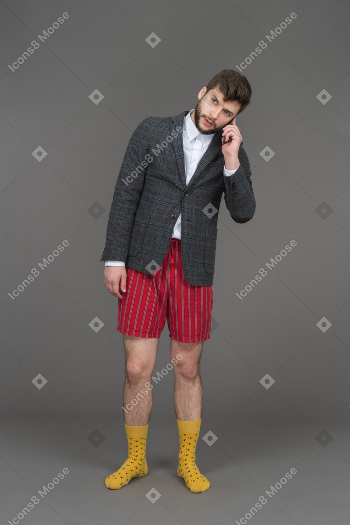 Joven en pantalones cortos rojos hablando por teléfono