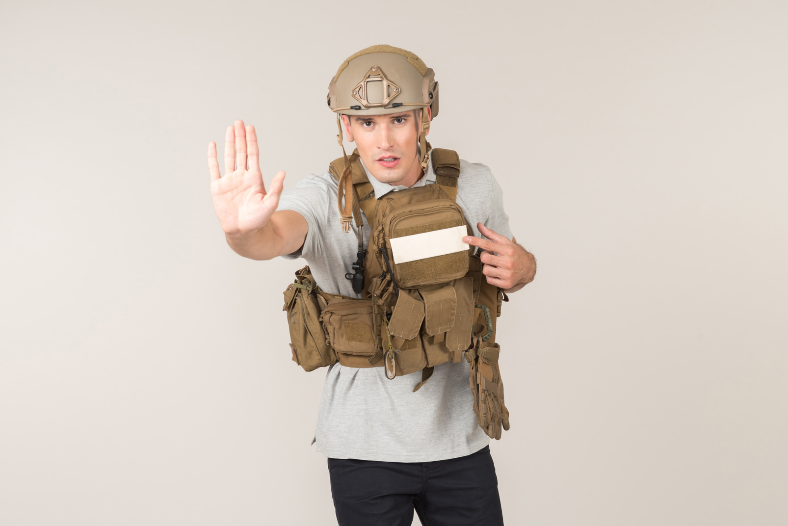 Male journalist in bulletproof vest showing stop gesture