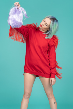 Young woman holding a purple wig