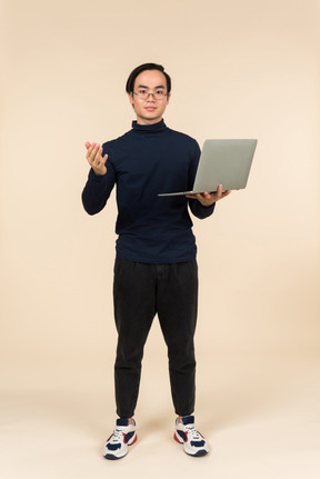 노트북을 제시하는 젊은 아시아 남자