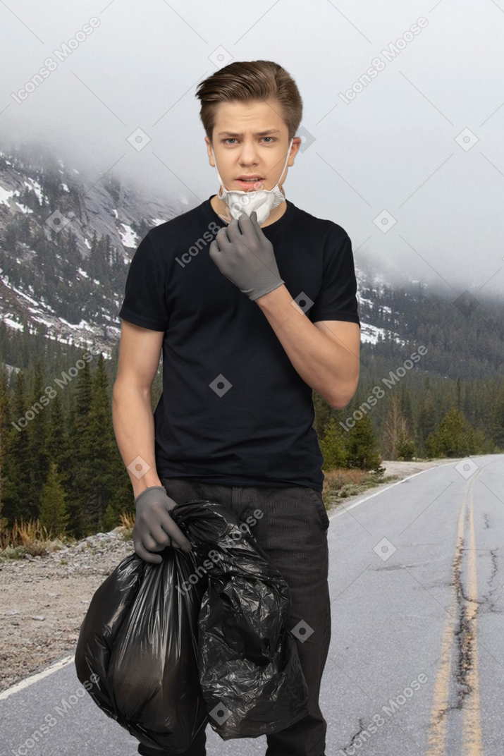 Man carrying a plastic bag in the mountains