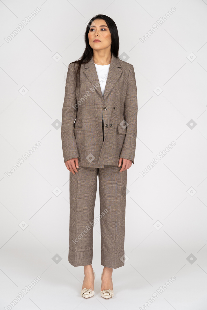 Front view of a young lady in brown business suit looking aside