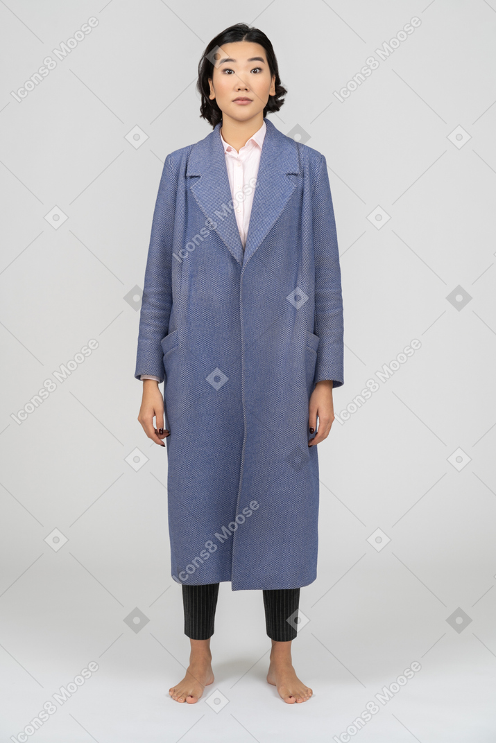 Surprised woman in blue coat with eyebrows raised