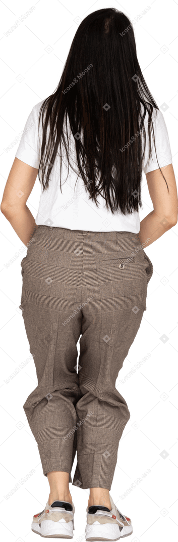 Vista posteriore di una giovane donna accovacciata in calzoni