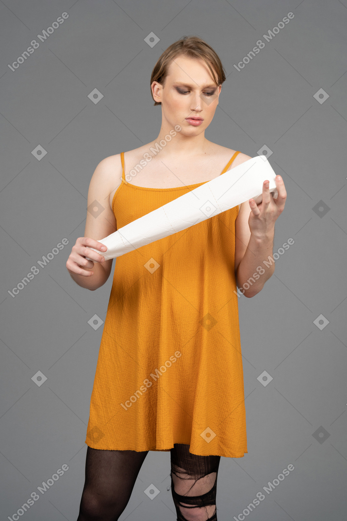 Young non-binary person unrolling toilet paper