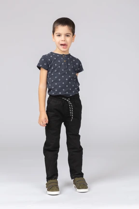 Front view of a cute boy looking at camera and showing tongue