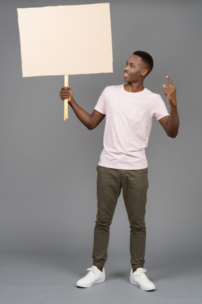 A smiling man holding a sign