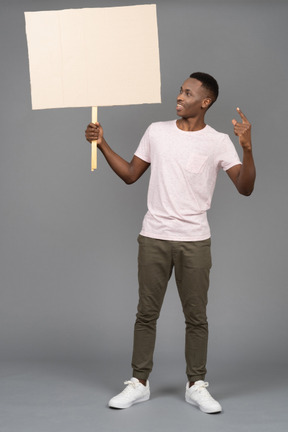 Un hombre sonriente sosteniendo un cartel