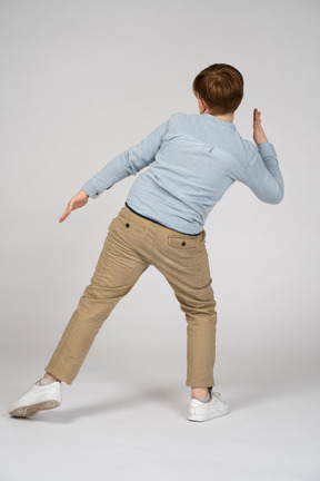 Back view of a young boy stepping to the side