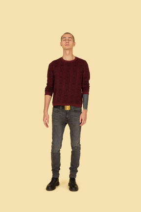じっと立っている赤いセーターを着た若い男の正面図